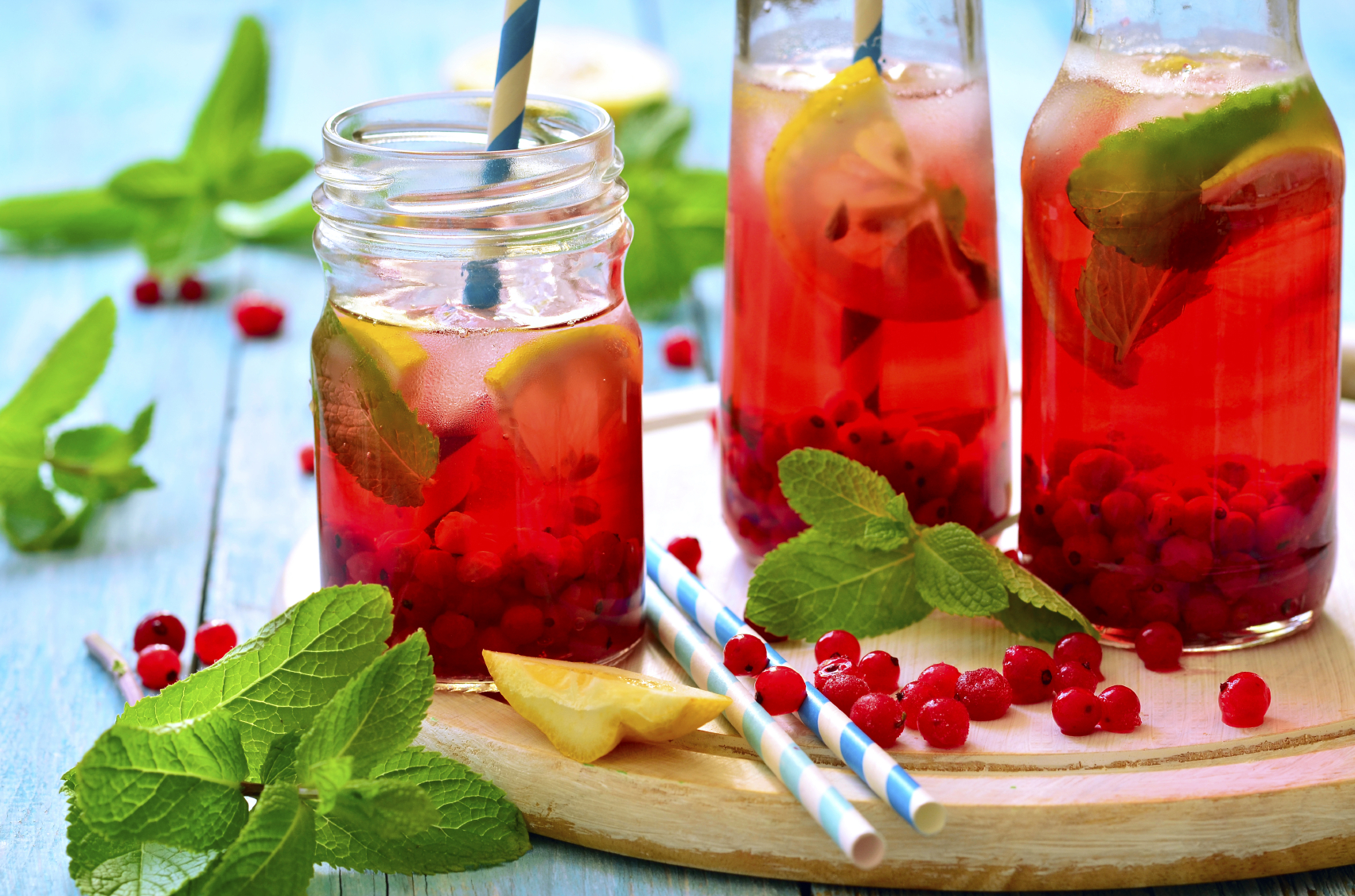 Cold redcurrant tea with lemon and mint in a glass jar.