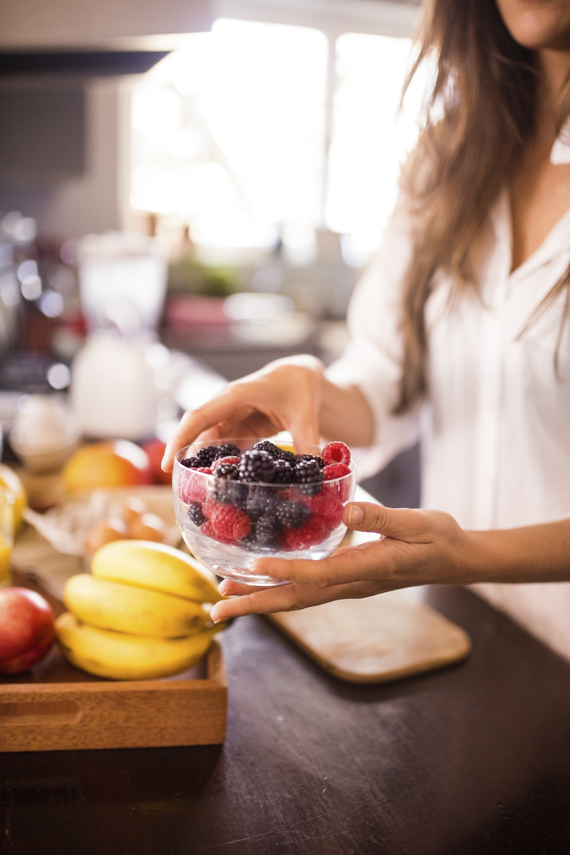Woman holding bowl of fresh berries for a healthy breakfast
