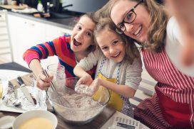 Family fun A mother with her two daughters making muffins and taking a selfie