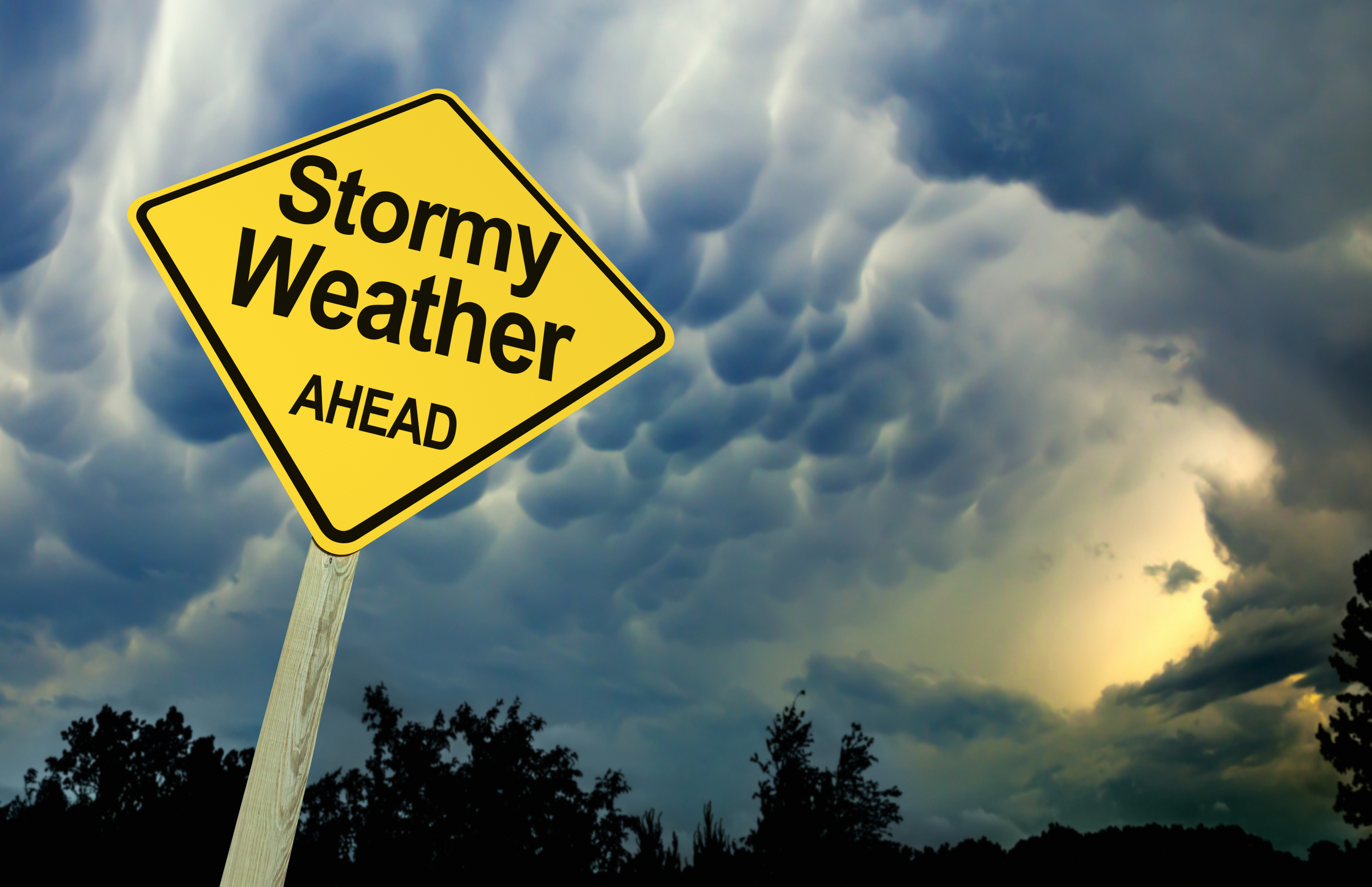 Stormy Weather Ahead Road Sign Against Dark Ominous Sky