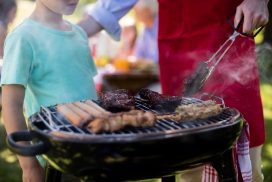 Father and son barbequing in the park Mid section of father and son barbequing in the park during day
