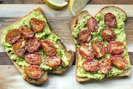 Avocado toast with roasted cherry tomatoes.  Top view, on board.Avocado toast with roasted cherry tomatoes.  Side view, on board.