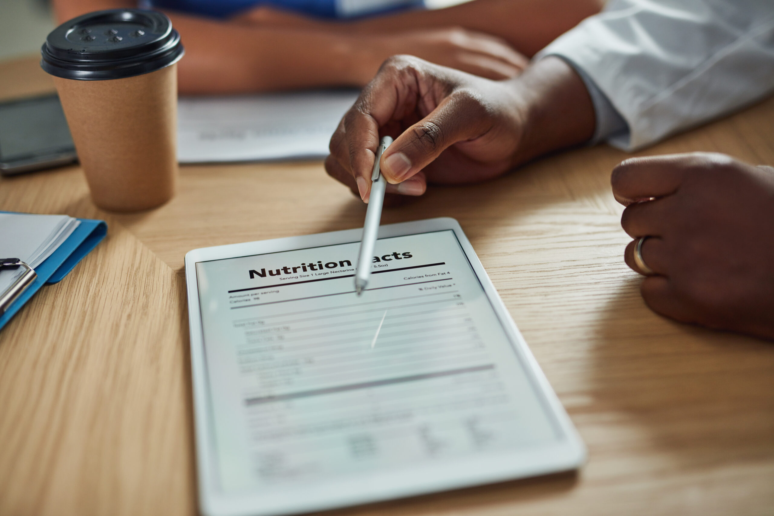 Closeup shot of an unrecognizable doctor pointing to a nutritional facts table on a digital tablet