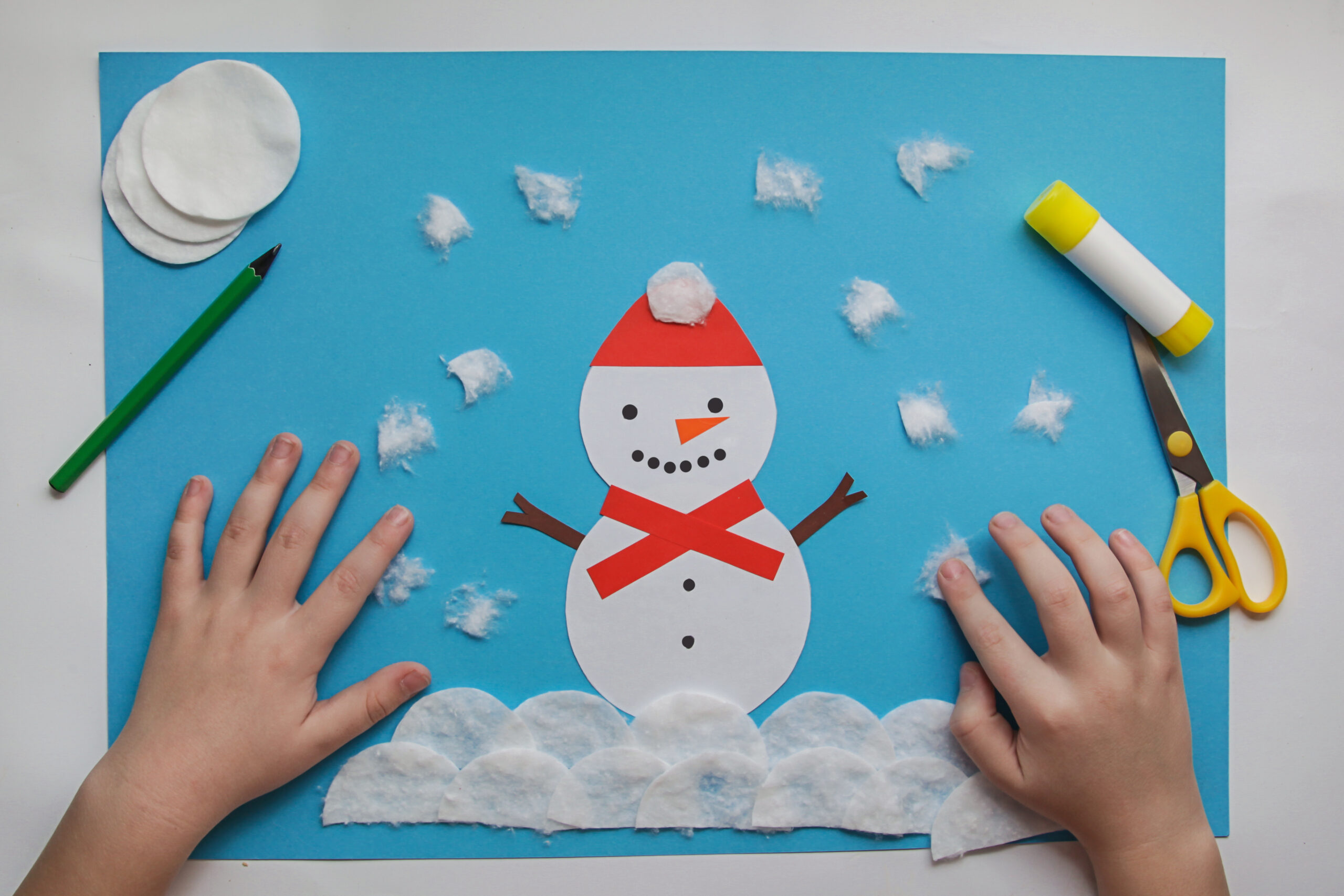 Easy Winter Crafts for kids. little child creative Snowman from paper and cotton disc. Children's art project. DIY concept. Handmade Easy Paper Crafts For Kids