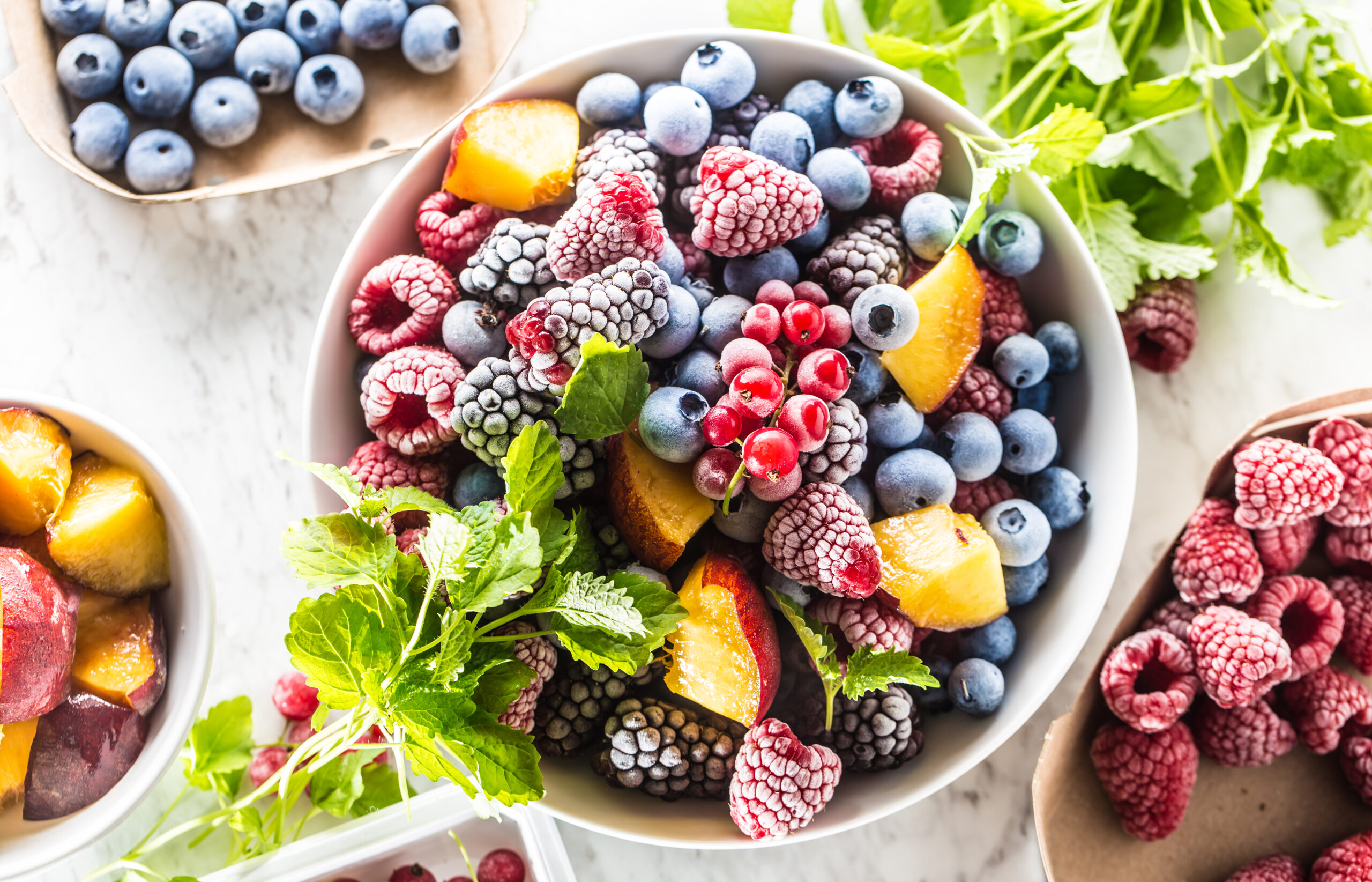 Frozen fruits blueberries blackberry raspberry red currant peach and herbs melissa.