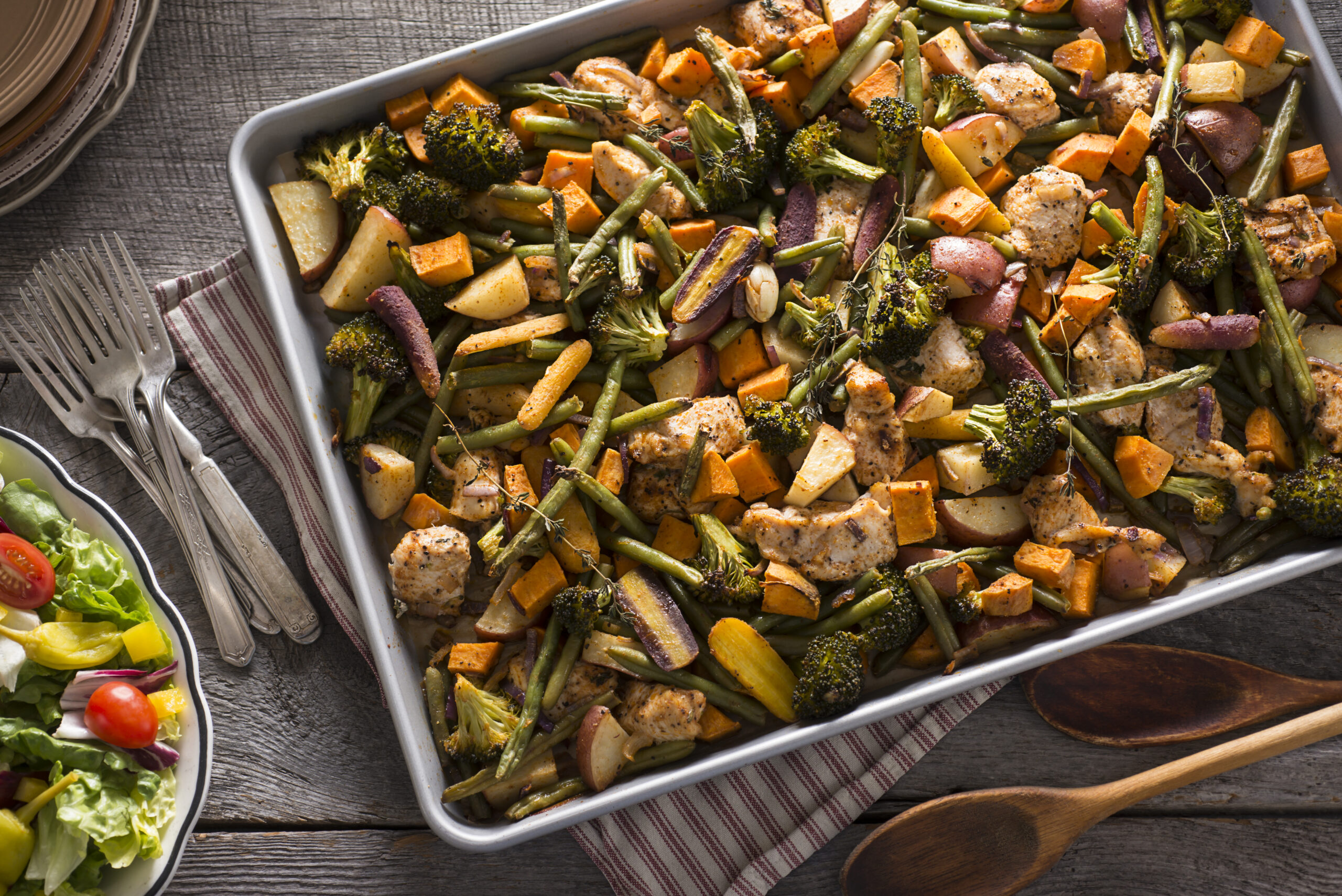 Chicken Sheet Pan Dinner with Broccoli, Red Potatoes, Green Beans, Sweet Potatoes, Rainbow Carrots, Onion and Thyme.