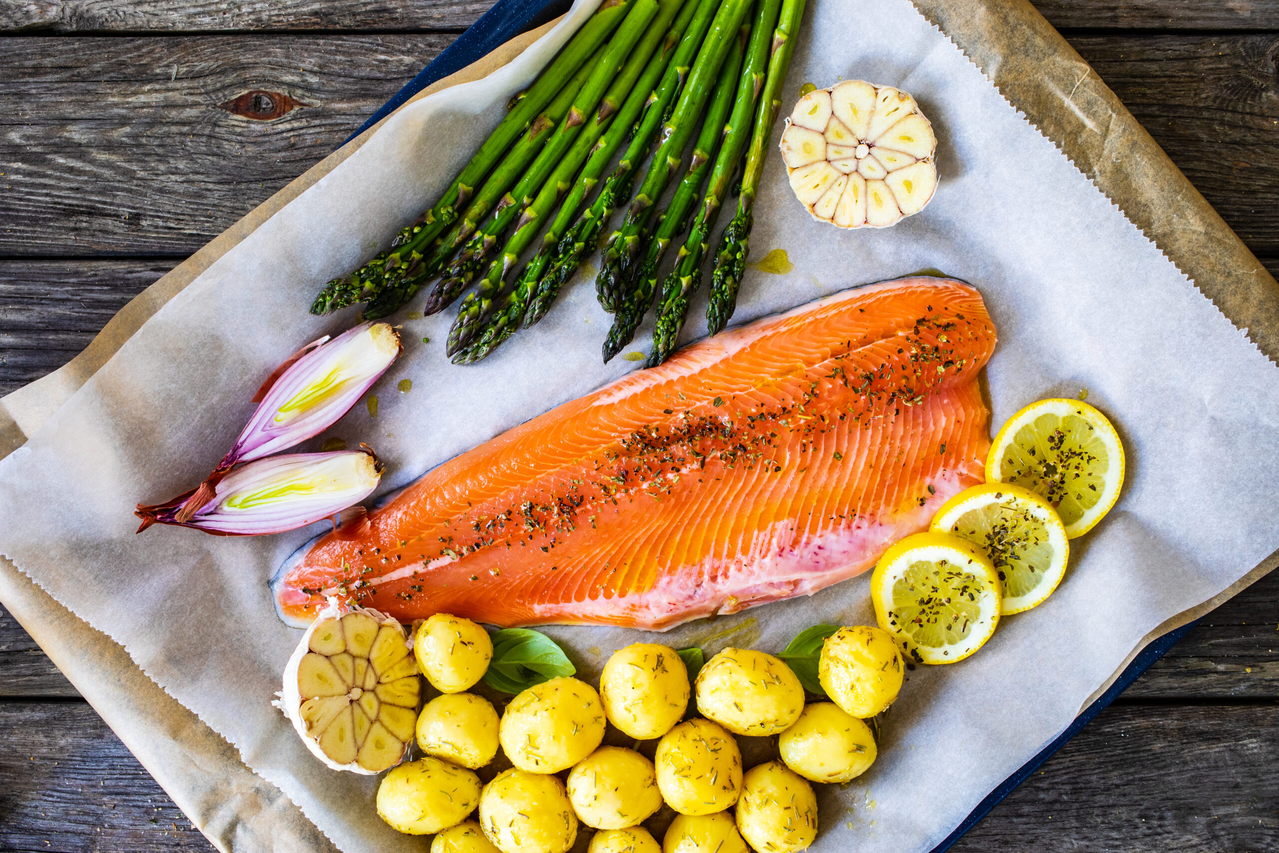 One sheet pan dinner ready to cook - fresh raw salmon fillet with fresh vegetables on cooking pan